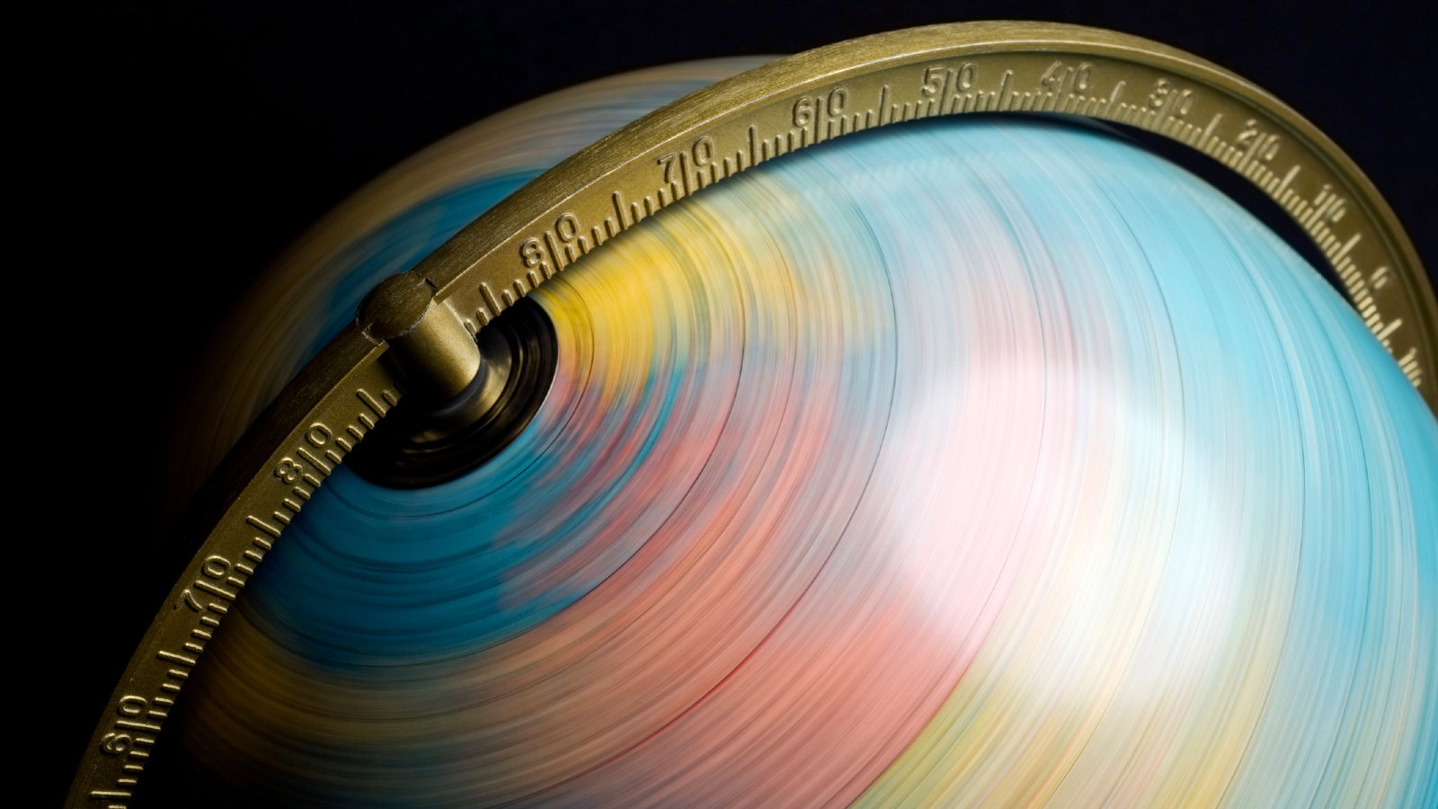 A globe spins in fast motion against a dark background