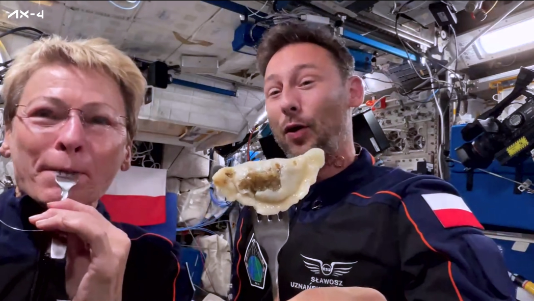 Two astronauts eat pierogis in space
