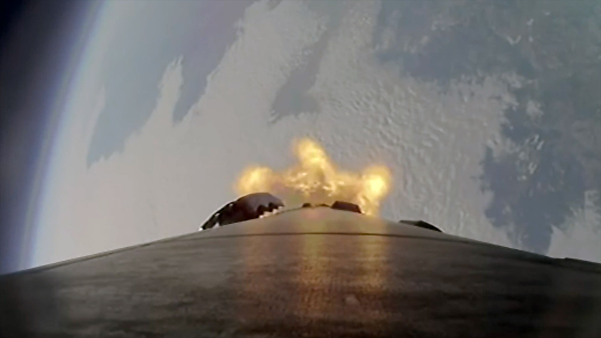 a downward-facing camera mounted on a rocket captures the Earth below as the booster climbs to space