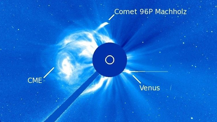An image of a comet near the Sun, which has been partially blocked out